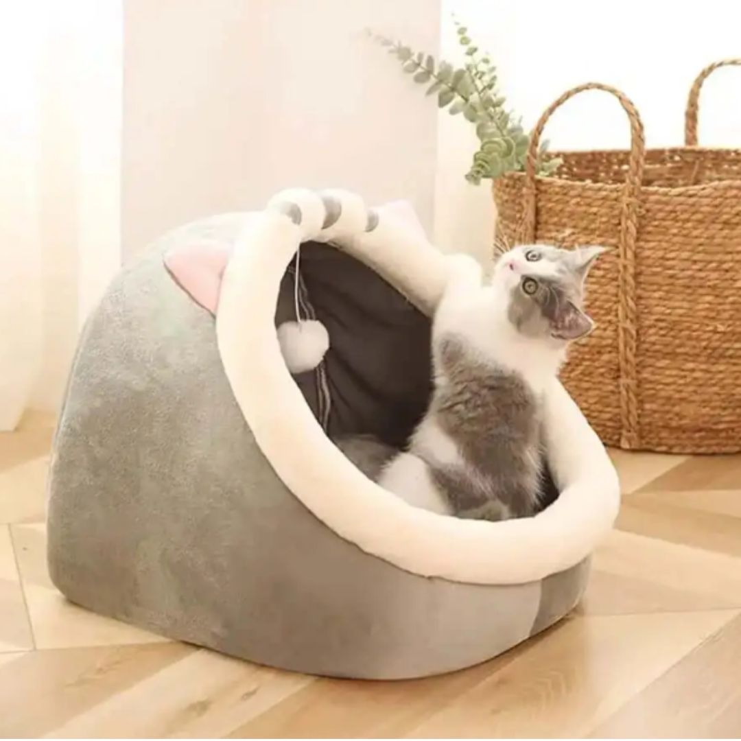 coussin en forme de chat avec un chat qui joue dedans de couleur gris et blanc